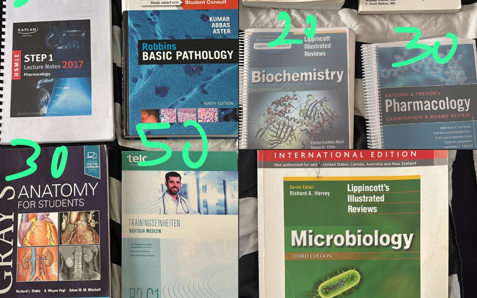 Second-hand medical textbooks laid out with prices written on